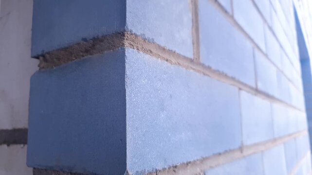 Brick construction. A brick wall made of dark blue bricks.