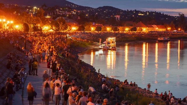 Szentendre Hungary Danube riverfront promenade time lapse of glowing evening lights and festival crowd along scenic riverbank