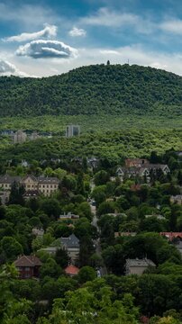 Budapest hillside time lapse of forested slopes and moving cloud shadows over Buda hills and Janos Hill residential district