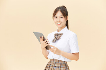 Smiling Female Student in Uniform Holding a Tablet for Learning