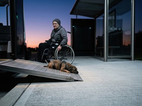 Wheelchair ramp at dusk with senior woman and assistance dog