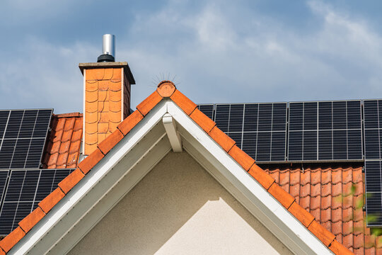 Solar panels on a house in a suburban area under a cloudy sky