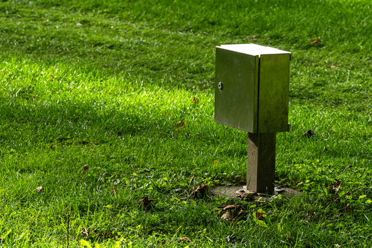 Metal box on metal pole in grassy area