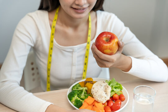 slim body asian women choose healthy foods, dieting female choose red apple for diet. Good healthy food. weight lose, balance, control, reduce fat, low calories, routines, exercise, body shape.