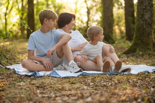 mother with sons having fun in the forest