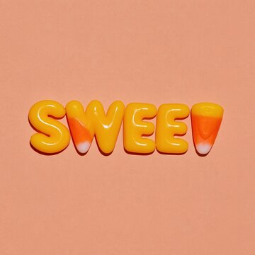 Glossy candy corn letters spelling sweet on a smooth peach background, featuring a vibrant tri-color design for seasonal holiday promotions
