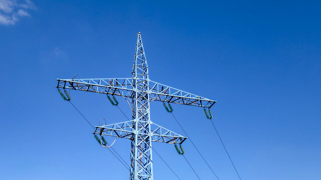 Electricity pylon supplying power across an interconnected grid, representing energy infrastructure, sustainable development, and global connectivity on a clear day