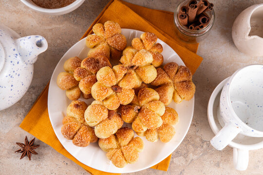 Pumpkin spice buns with almond nuts, cinnamon and sugar crunch. Autumn baking idea, pumpkin puree based vegetable rolls in form of small pumpkins. Tiny sweet pumpkin shaped buns on white plate,