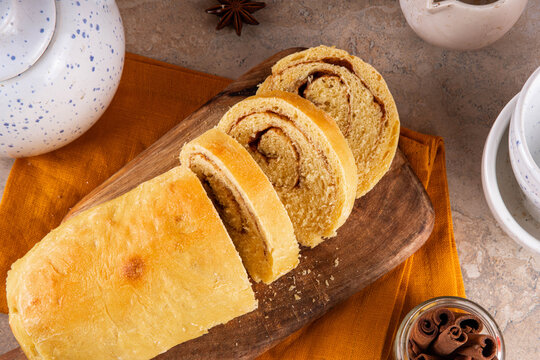 Sourdough Pumpkin Cinnamon Swirl Bread.  Cinnamon roll bread loaf bun with pumpkin puree based dough, tasty sweet cinnamon swirls, on beige background copy space