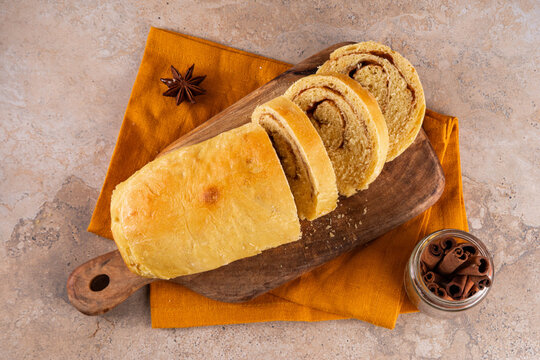 Sourdough Pumpkin Cinnamon Swirl Bread.  Cinnamon roll bread loaf bun with pumpkin puree based dough, tasty sweet cinnamon swirls, on beige background copy space