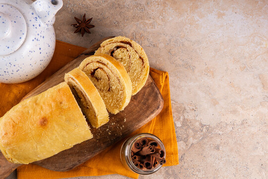 Sourdough Pumpkin Cinnamon Swirl Bread.  Cinnamon roll bread loaf bun with pumpkin puree based dough, tasty sweet cinnamon swirls, on beige background copy space