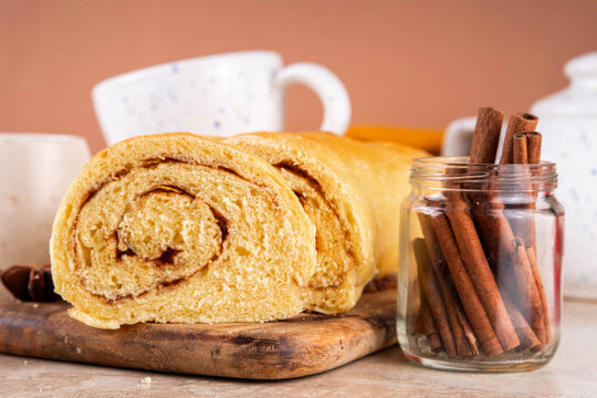 Sourdough Pumpkin Cinnamon Swirl Bread.  Cinnamon roll bread loaf bun with pumpkin puree based dough, tasty sweet cinnamon swirls, on beige background copy space