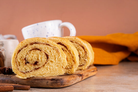 Sourdough Pumpkin Cinnamon Swirl Bread.  Cinnamon roll bread loaf bun with pumpkin puree based dough, tasty sweet cinnamon swirls, on beige background copy space