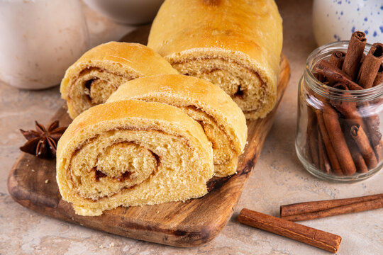 Sourdough Pumpkin Cinnamon Swirl Bread.  Cinnamon roll bread loaf bun with pumpkin puree based dough, tasty sweet cinnamon swirls, on beige background copy space