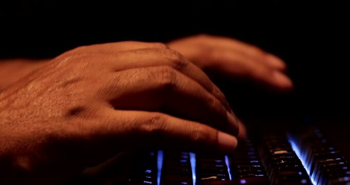 Close-Up of Man Hands Typing on Backlit RGB Mechanical Gaming Keyboard in Dark Office
