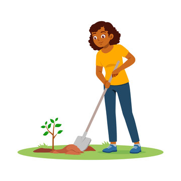 Happy African American woman planting a small tree with a shovel on green grass smiling cheerfully