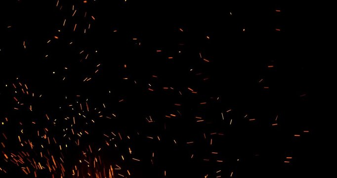 Slow motion fiery sparks flying through the air isolated on black background. Ideal as overlay effect for video editing, cinematic transitions, VFX compositing and motion graphics.