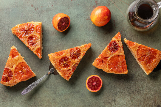 Homemade red orange upside down pie . Tropical dessert on green background. Top view
