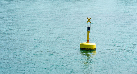 A yellow solar navigation buoy floats on blue water with its reflection. Concept of navigation, safety, transit, equipment and marine infrastructure © Анна Зеленая