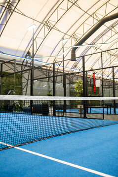Picture of a paddle tennis court interior with no one there