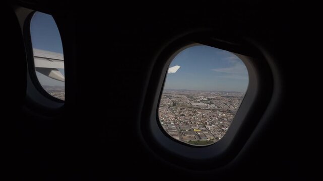 Static Airplane Window View Over Vast Urban Landscape at Dusk