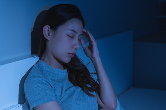 Depressed anxiety asian young woman, girl frustrated closed eyes, touching face, suffering stressed, sick, tired, crisis sitting on bed from headache, migraine pain tension problem health care concept