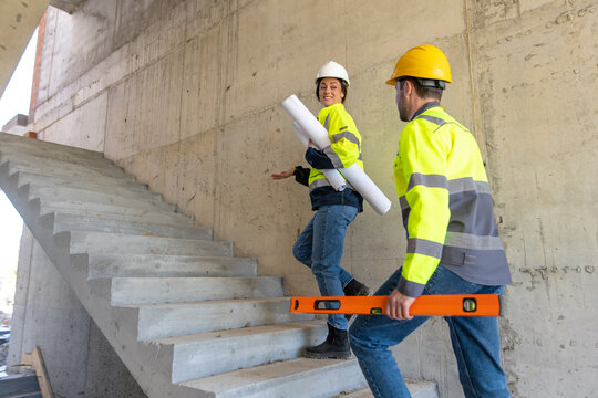 Female architect carrying blueprints and guiding colleague