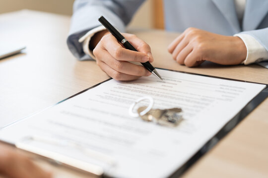Property lease concept, asian woman tenant, client rental purchase, buyer apartment or home with landlord hand document signing contract, holding pen putting signs signature paper on desk office.