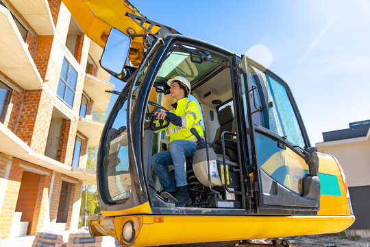 Female excavator operator driving heavy machinery