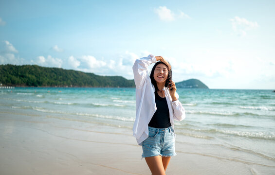 Trendy young traveler enjoying sunny weather and coastal breeze on a luxury tropical island resort