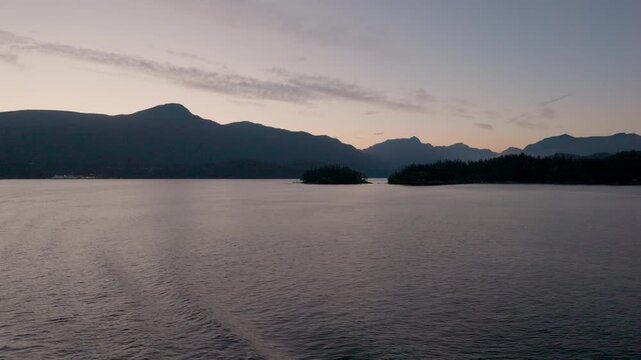 Evening sunset from a boat or ship with a view of the Coast Mountains of British Columbia, Canada travel and tourism