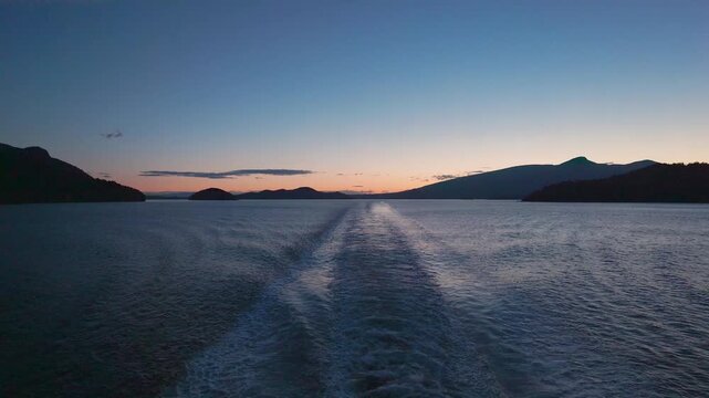 Sunset from the stern of a ship or ferry with Bowen and Gambier Island in view travel and tourism