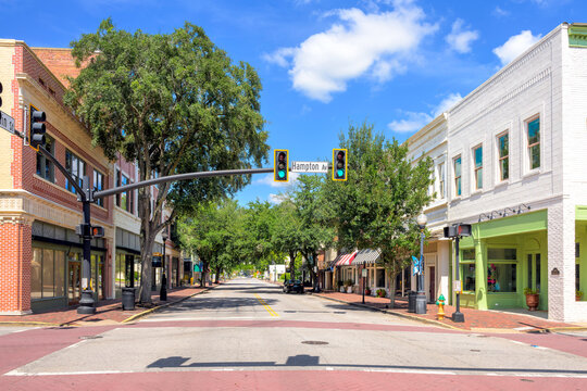 Late 19th century brick buildings with storefronts and cafes on the tree lined Main Street of the Southern small town of Sumter, South Carolina.