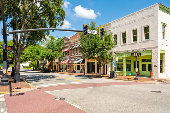 Late 19th century brick buildings with storefronts and cafes on the tree lined Main Street of the Southern small town of Sumter, South Carolina.