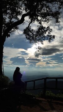 Traveler Photographing Mountain Landscape Under Dramatic Cloudy Sky