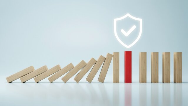 Wooden dominoes falling with a red stopper block and shield icon, illustrating risk management and prevention on a light blue background.