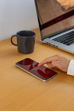Vertical image of man touching smartphone with security alert