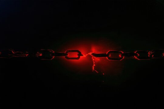 Broken chain with a glowing red fractured link in a dark void, featuring sharp edges and electric particles for cybersecurity and data breach concepts