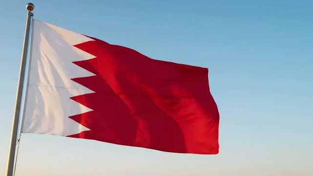 National bahrain flag waving on flagpole against clear blue sky