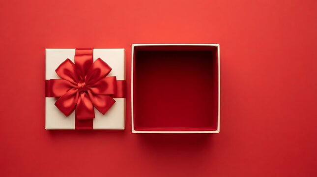 Open gift box with a red ribbon bow on a solid red background