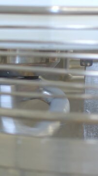 stationary metal appliance interior components shown behind horizontal grill bars with circular gasket seal and stacked trays in tight close view detail, with