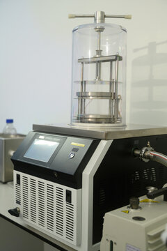 Vertical image of Laboratory Freeze Dryer Machine with Clear Chamber and Digital Control Panel in Scientific Research Facility