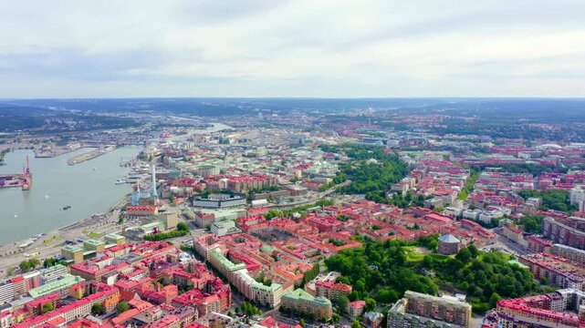Gothenburg, Sweden. Panoramic Drone footage over the historic city center and the Gota River, dense red rooftops and green parkland under an overcast sky. Drone footage