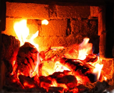 Fire burns in a brick fireplace during the evening hours creating warmth and light