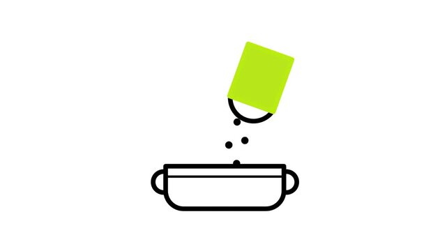 A bright green container pours small black seasoning particles continuously into an open bowl resting on a clean white surface during a cooking food preparation process