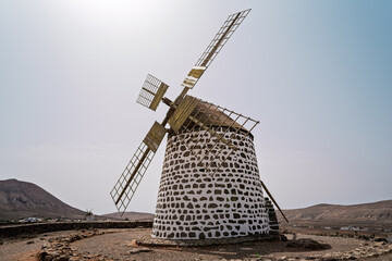 A traditional stone windmill stands with a second mill visible in the distance near Villaverde, La Oliva, Fuerteventura, Canary Islands, Spain. © Sergey Kohl