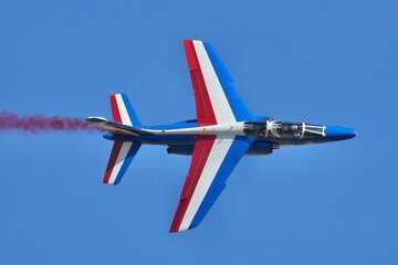 Obraz premium Patrouille de France avion fumée rouge vue coté