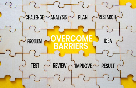 Overcome barriers symbol. Concept words overcome barriers on wooden puzzle pieces. Beautiful yellow background. Problem solving concept. Copy space.