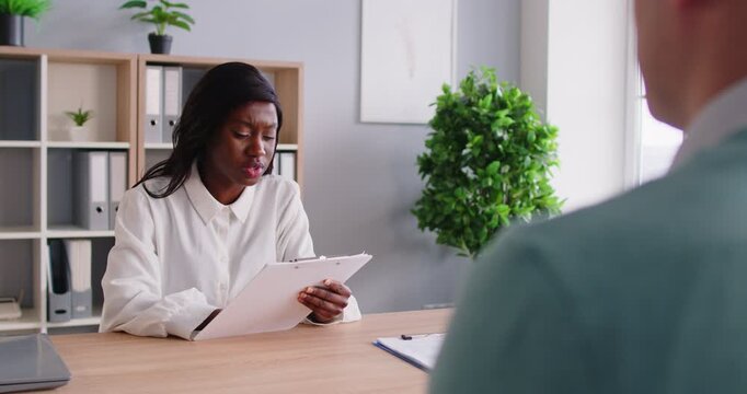 Professional HR manager asking questions to male job applicant during interview in office. Female recruiter talking to candidate, analyzing work experience and qualifications. Human resources concept.