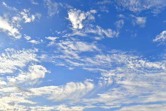 A blue sky with thin, wispy cirrus clouds, also known as feather clouds